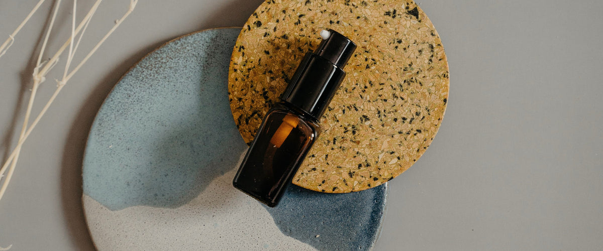 Serum bottle and cap resting on ceramic dishes