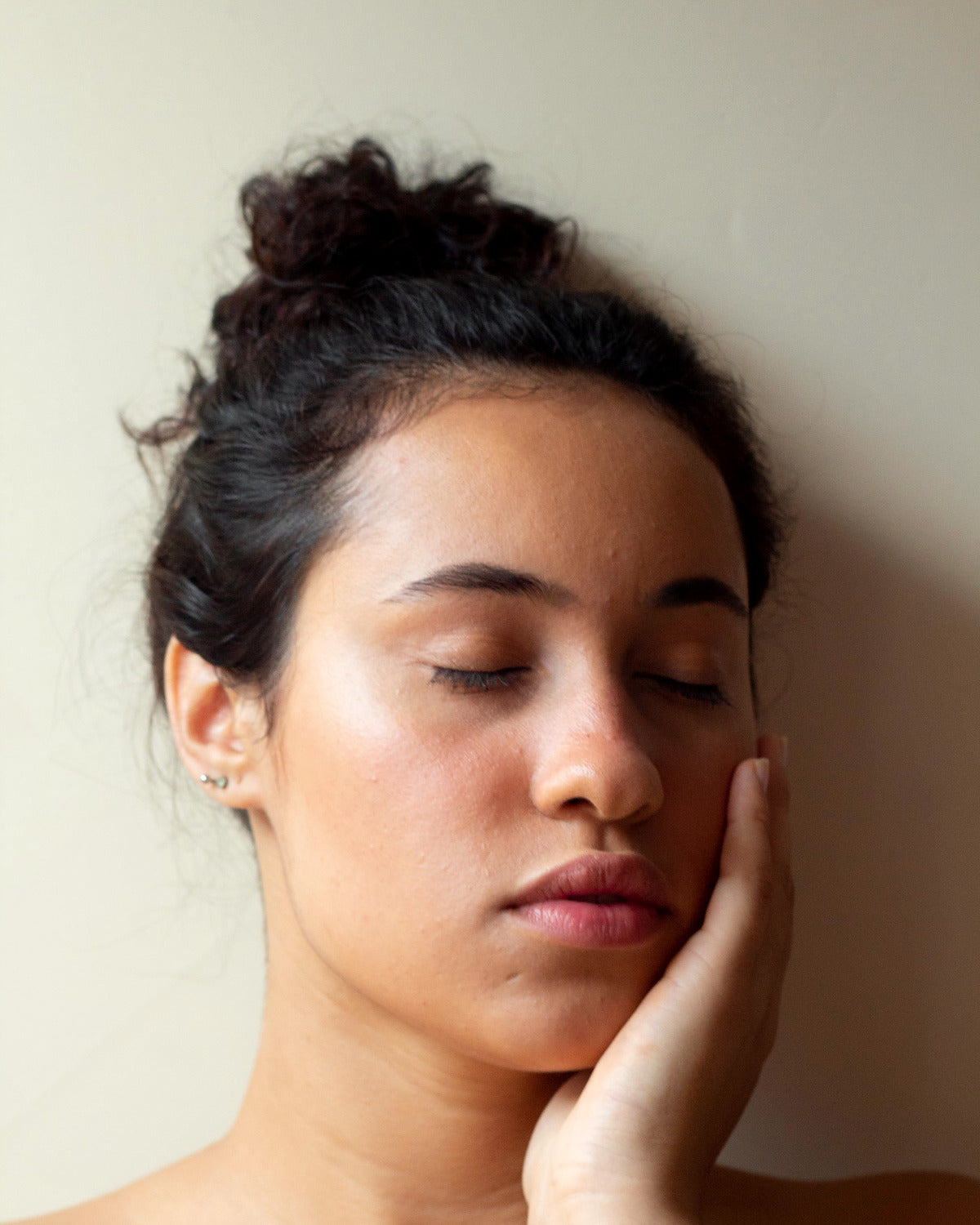 Woman with closed eyes resting her cheek in her hand